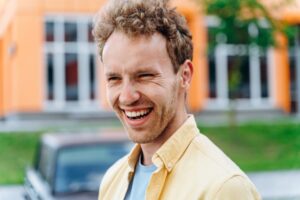 Side view. Positive guy on the background of the city.